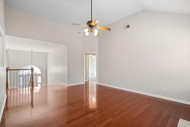 spare room featuring high vaulted ceiling, wood finished floors, visible vents, and baseboards