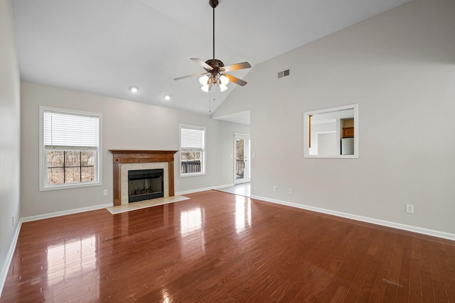 unfurnished living room featuring a fireplace, visible vents, a ceiling fan, wood finished floors, and baseboards