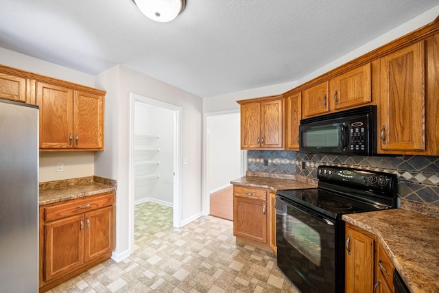 kitchen featuring black appliances, baseboards, brown cabinetry, and decorative backsplash