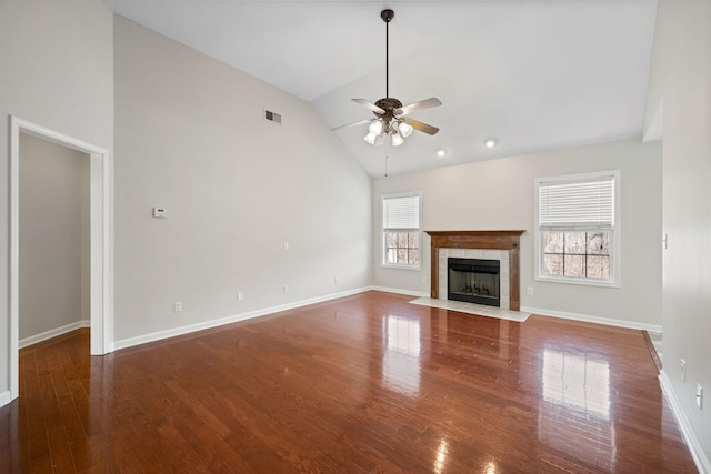 unfurnished living room with baseboards, visible vents, a ceiling fan, a tile fireplace, and wood finished floors