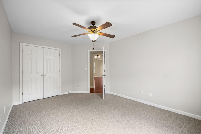 unfurnished bedroom with a closet, carpet, a ceiling fan, and baseboards