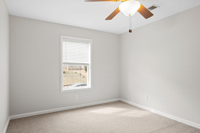 carpeted empty room featuring a ceiling fan, visible vents, and baseboards