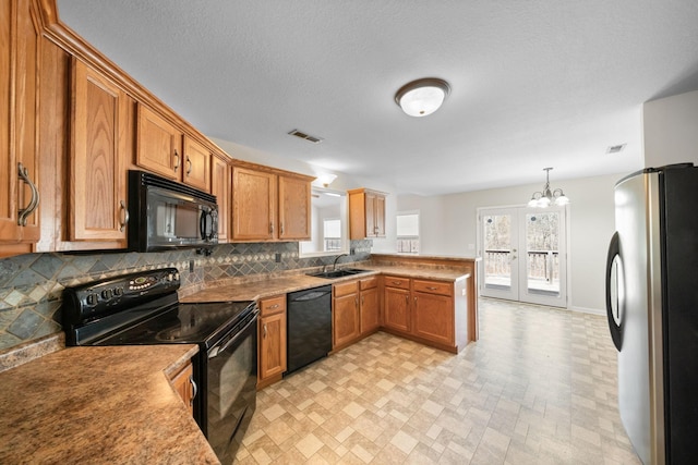 kitchen with black appliances, visible vents, brown cabinets, and a sink