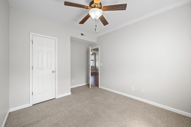 unfurnished bedroom featuring carpet floors, visible vents, ceiling fan, and baseboards