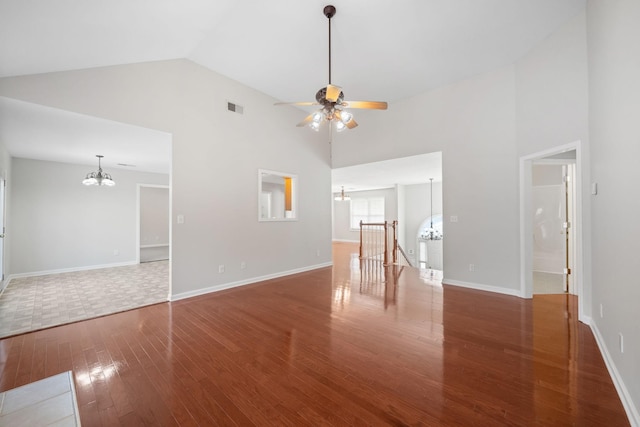 unfurnished living room featuring ceiling fan with notable chandelier, high vaulted ceiling, hardwood / wood-style floors, and visible vents