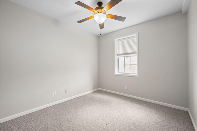 spare room with carpet flooring, a ceiling fan, and baseboards