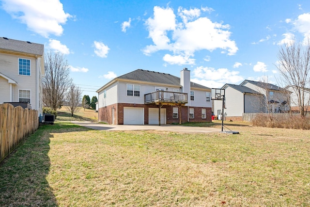 back of house with concrete driveway, brick siding, a lawn, and an attached garage