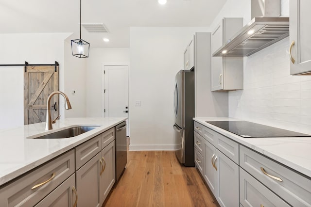 kitchen with gray cabinets, pendant lighting, sink, stainless steel appliances, and wall chimney exhaust hood