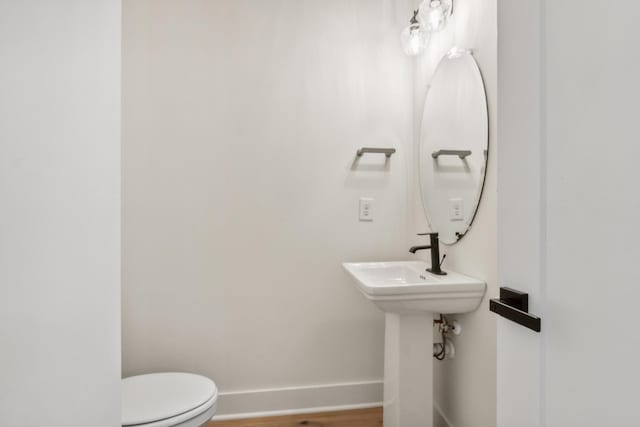 bathroom with hardwood / wood-style floors and toilet