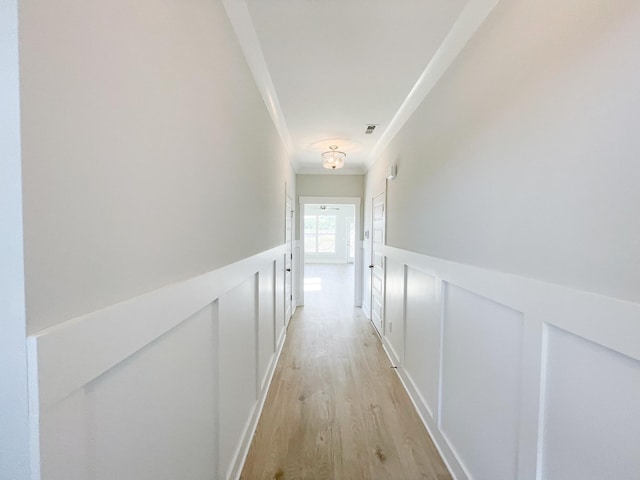 hall featuring ornamental molding and light wood-type flooring