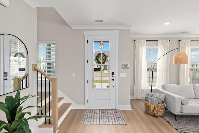 foyer featuring crown molding and light wood-type flooring