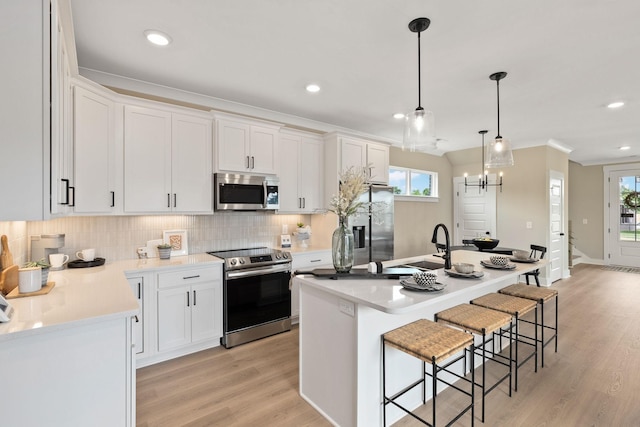 kitchen featuring white cabinetry, appliances with stainless steel finishes, and a center island with sink