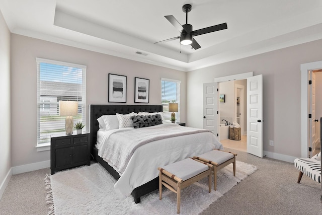 carpeted bedroom featuring a raised ceiling, ceiling fan, and multiple windows