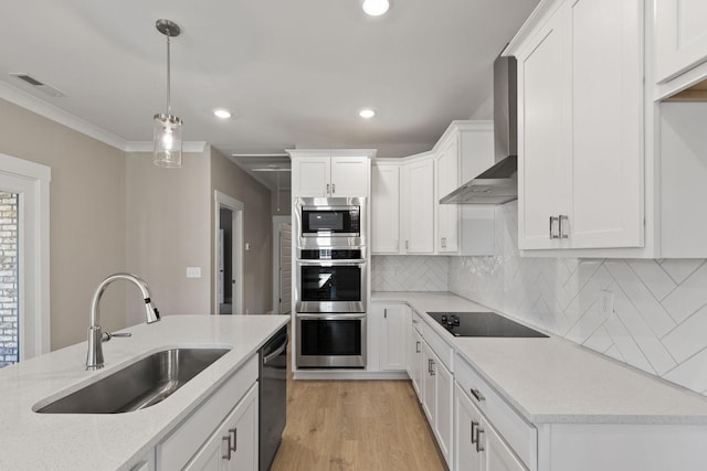 kitchen with wall chimney exhaust hood, sink, light stone counters, white cabinets, and black appliances