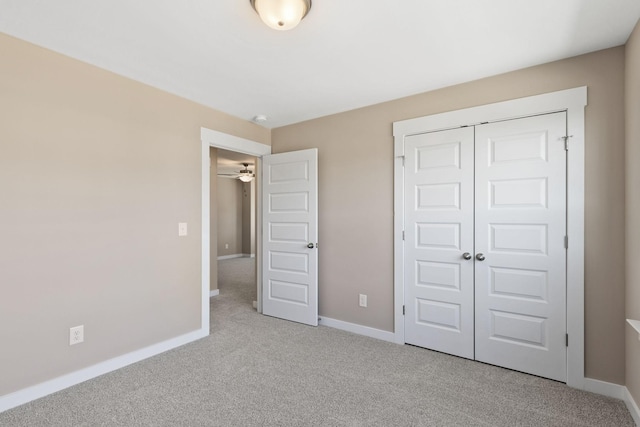 unfurnished bedroom featuring light carpet and a closet