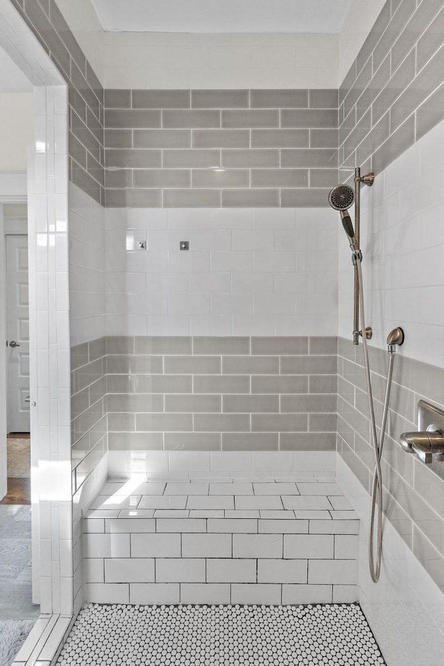 bathroom featuring tiled shower and tile patterned flooring