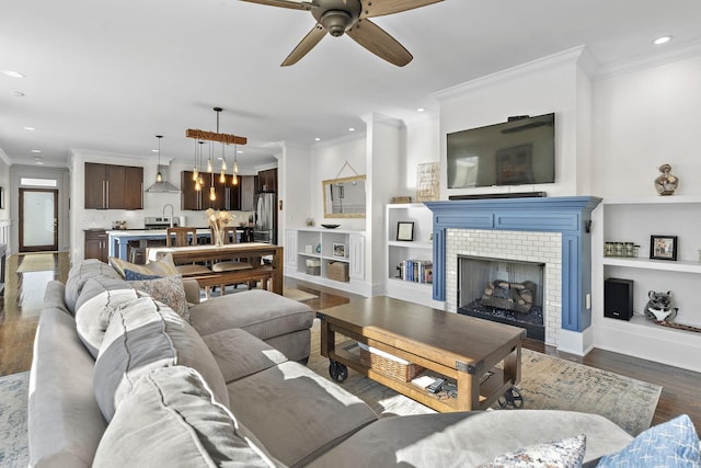 living room with crown molding, ceiling fan, and dark hardwood / wood-style floors