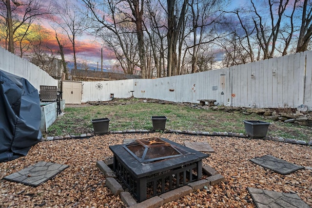 yard at dusk featuring an outdoor fire pit