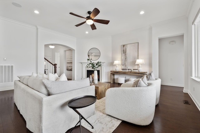 living room featuring ceiling fan, ornamental molding, and dark hardwood / wood-style flooring