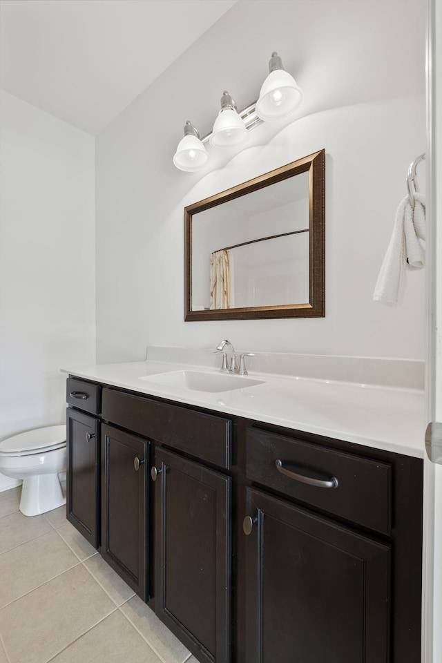 bathroom with tile patterned flooring, vanity, toilet, and walk in shower