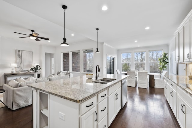 kitchen featuring sink, light stone counters, dishwasher, an island with sink, and white cabinets