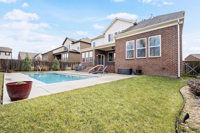 back of house with a fenced in pool, a patio, a yard, and ceiling fan