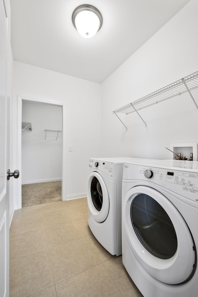 laundry area featuring separate washer and dryer and light tile patterned flooring