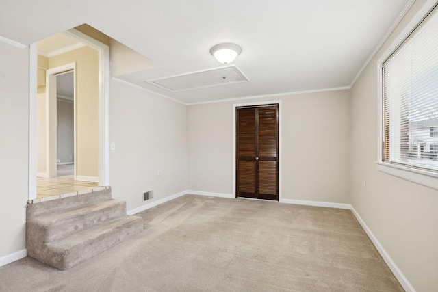 empty room with crown molding and light colored carpet