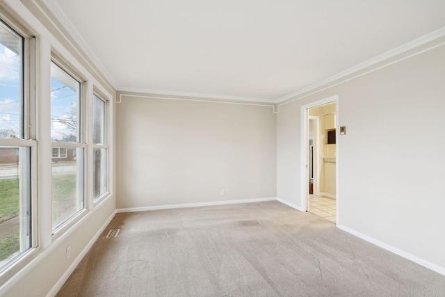 unfurnished room featuring crown molding, a wealth of natural light, and light carpet