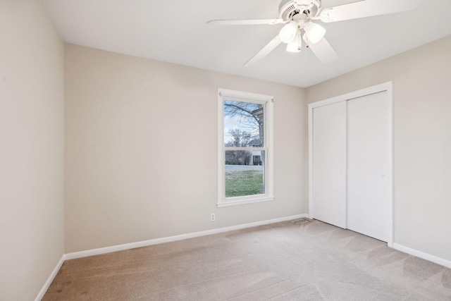 unfurnished bedroom with light carpet, ceiling fan, and a closet