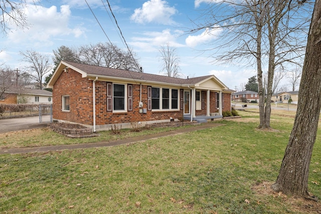 ranch-style house featuring a front yard and covered porch