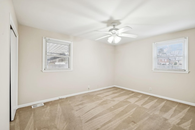 unfurnished bedroom featuring light carpet, ceiling fan, and a closet