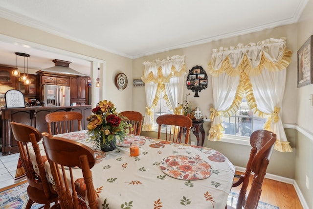 dining room with crown molding and light wood-type flooring