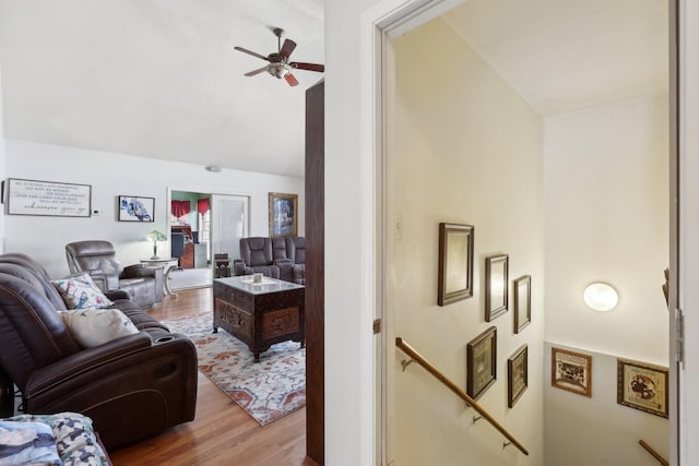 living room featuring lofted ceiling, light hardwood / wood-style flooring, and ceiling fan