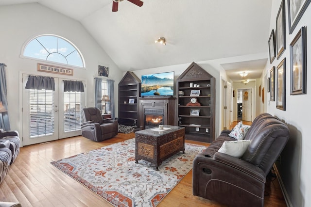 living room featuring light hardwood / wood-style flooring, plenty of natural light, high vaulted ceiling, and ceiling fan