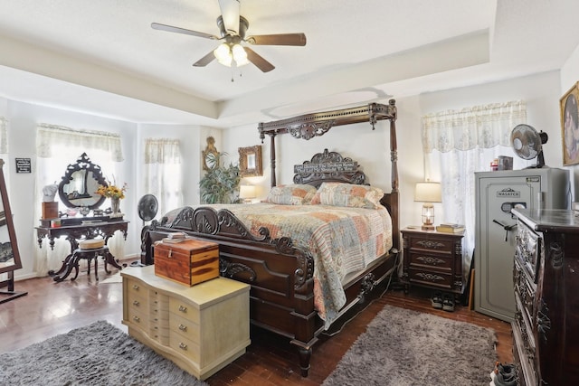 bedroom featuring ceiling fan and a raised ceiling