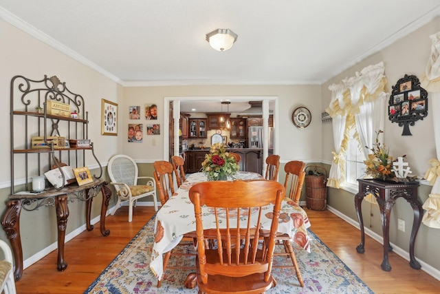 dining area featuring crown molding and light hardwood / wood-style flooring