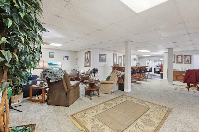 carpeted living room with a paneled ceiling