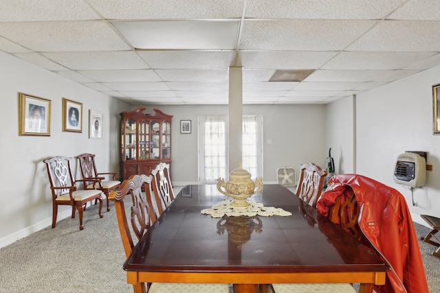 dining area featuring carpet floors, a paneled ceiling, and heating unit