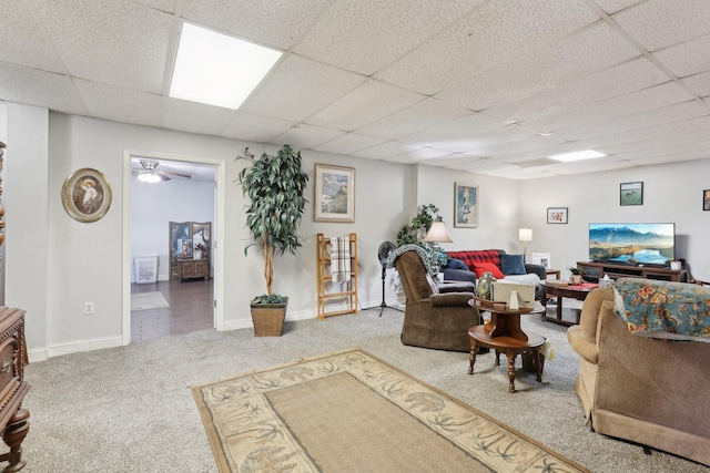 carpeted living room featuring a drop ceiling