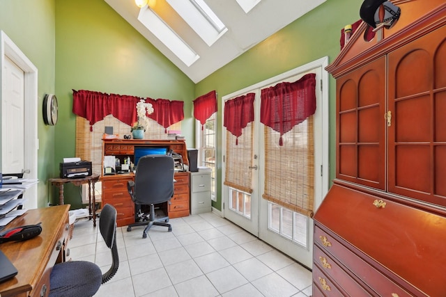 office area with light tile patterned floors, high vaulted ceiling, and a skylight