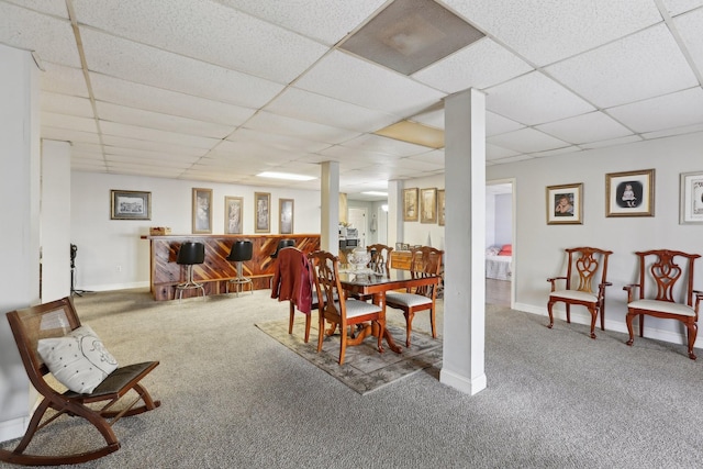 carpeted dining room featuring a drop ceiling and bar area