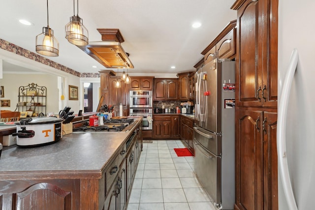 kitchen with light tile patterned flooring, tasteful backsplash, crown molding, hanging light fixtures, and appliances with stainless steel finishes