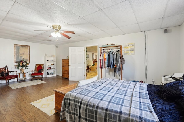 bedroom featuring wood-type flooring, ceiling fan, and a paneled ceiling