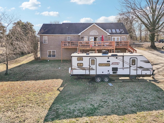 back of property featuring a yard and a deck