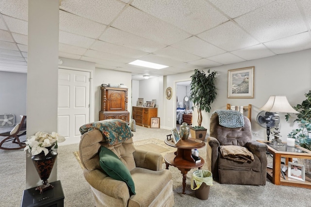 carpeted living room with a drop ceiling