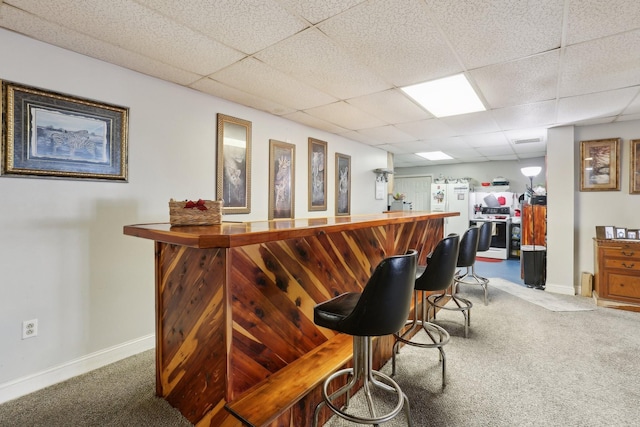 bar with carpet flooring and a paneled ceiling