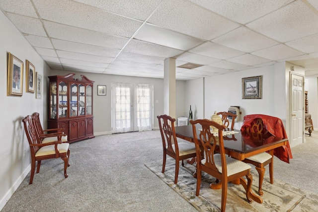 carpeted dining space with a drop ceiling and french doors