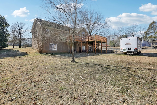 rear view of house with a deck and a lawn