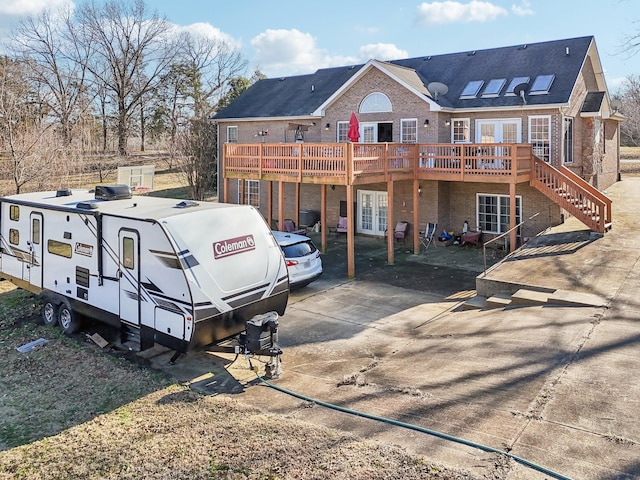 rear view of property featuring a wooden deck and french doors